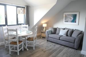 uma sala de estar com um sofá e uma mesa em The Harbour Retreat em Birdham