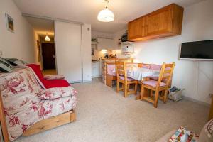 a living room with a couch and a table and a kitchen at VALFREJUS appartement 2 pièces 35m2, au pied des pistes avec balcon in Modane
