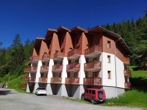 a building with a red van parked in front of it at VALFREJUS appartement 2 pièces 35m2, au pied des pistes avec balcon in Modane