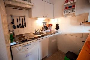 a small kitchen with a sink and a stove at VALFREJUS appartement 2 pièces 35m2, au pied des pistes avec balcon in Modane +2 photos
