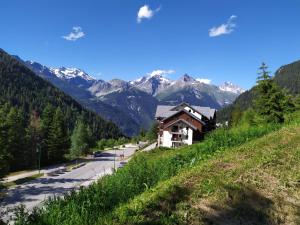 a mountain road with a house on the side of a hill at VALFREJUS appartement 2 pièces 35m2, au pied des pistes avec balcon in Modane