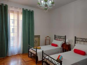 ミラノにあるBnbook-Villa Molinariのベッドルーム1室(ベッド2台、シャンデリア付)