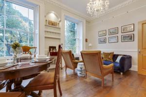 a dining room with a table and chairs at Bright Camberwell Georgian Apartment in London