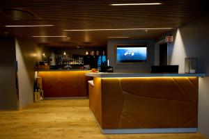 a lobby with a bar with a television on the wall at Svalbard Hotell | Polfareren in Longyearbyen