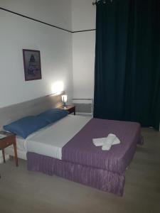 HOTEL SYLVABELLE في مارسيليا: غرفة نوم مع سرير مع قبعة عليه