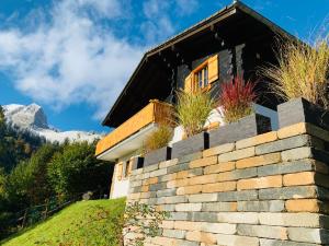 a house in the mountains with a retaining wall at Chalet Edelweiss in Moleson