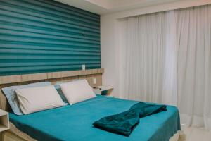 ein Schlafzimmer mit einem Bett mit einer grünen Decke darauf in der Unterkunft In Mare Bali Resort Beira Mar by Qavi - 224 in Granja Beira Mar + 7 Fotos