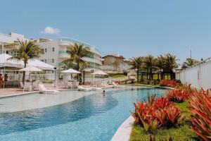una gran piscina con palmeras y edificios en Qavi - Flat Beira Mar Cotovelo #InMare224, en Parnamirim