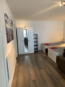 a room with two beds and a room with wooden floors at Gemütlich wohnen zwischen Köln und Düsseldorf in Leverkusen