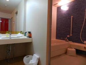 a bathroom with a sink and a toilet and a tub at Hotel Mariage Tsukuba in Tsukuba