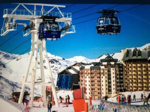 a ski lift with people on it in the snow at Les temples du soleil in Val Thorens