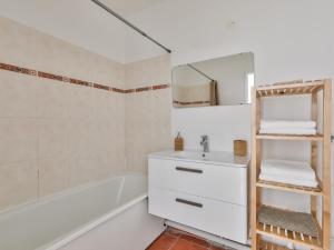 La salle de bains est pourvue d'un lavabo, d'une baignoire et d'un miroir. dans l'établissement 123home-Le park side, à Chessy