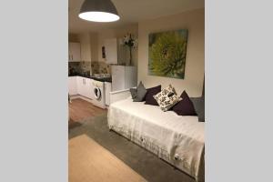 a bedroom with a white bed and a kitchen at Louis Lodge in Salisbury