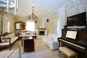 a living room with a piano and a couch at Villa Oasis in Kamilari