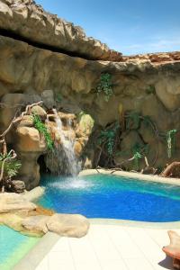 einen Pool mit Wasserfall in einem Resort in der Unterkunft Motel Del Rey in Salvador