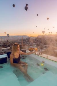 a woman sitting in a swimming pool on a building at Arinna Cappadocia in Göreme