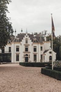 a white house with a flag in front of it at NOYR. tiny house in Nunspeet