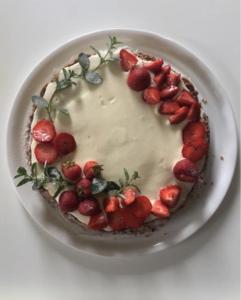 a cake with strawberries on a plate on a table at Casa Blu Cobalto in Maiori