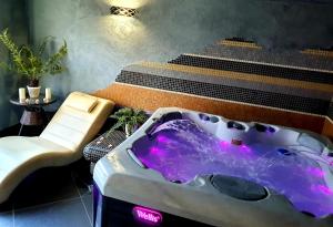 a hot tub in a room with a chair and stairs at Góral Spa&Wellness in Szczyrk