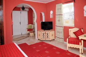 a bedroom with a bed and a tv in it at Dar Amphora Menzel in Midoun