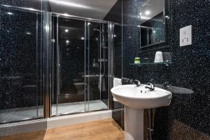 a bathroom with a glass shower and a sink at Manor House Hotel Holy Island in Berwick-Upon-Tweed