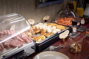 un buffet de différents types de nourriture sur une table dans l'établissement Hôtel La Villefromoy, à Saint-Malo