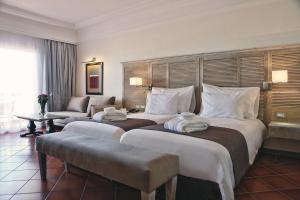 una camera d'albergo con due letti e un divano di Hotel Riu Tikida Beach - All Inclusive Adults Only ad Agadir