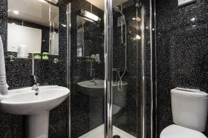 a bathroom with a toilet and a sink and a shower at Manor House Hotel Holy Island in Berwick-Upon-Tweed