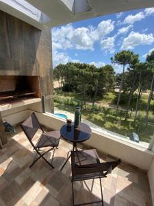 a patio with a table and two chairs and a pool at Pinamar Complejo Amarras in Pinamar
