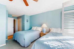 two beds in a bedroom with blue walls at Sea Pines Village - 5 Sea Pines Village in Bethany Beach +30 photos