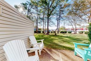 two white chairs sitting on the side of a house at Sea Pines Village - 5 Sea Pines Village in Bethany Beach