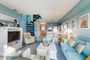 a living room with a blue couch and a tv at Sea Pines Village - 5 Sea Pines Village in Bethany Beach