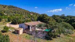 a small house on a hill with a swimming pool at Finca Es Garballó in Son Servera