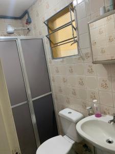 La salle de bains est pourvue de toilettes, d'une douche et d'un lavabo. dans l'établissement Condomínio Villagio Maranduba - Apenas 5 min á pé da praia - Bl 7, à Ubatuba
