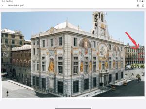 duży biały budynek z wieżą zegarową na górze w obiekcie Palazzo San Giorgio ( S ) w Genui