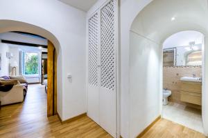 um arco leva a uma casa de banho com um WC e um lavatório. em Deluxe Apartment - Campo dei Fiori em Roma