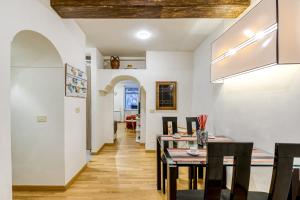 uma sala de jantar com paredes brancas e uma mesa e cadeiras em Deluxe Apartment - Campo dei Fiori em Roma