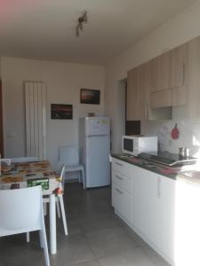 cocina con nevera blanca y mesa en Gorizia vacanze, en Gorizia
