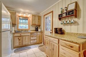 a kitchen with wooden cabinets and a white refrigerator at Close To Adventure Heart Of Linville Falls in Newland