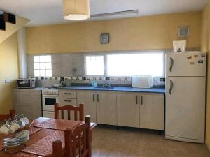a kitchen with a white refrigerator and a table at Atlantis Park in Mar de Ajó