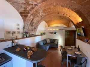 a kitchen and living room with a brick archway at Frantoio-di-Campiglia in Campiglia Marittima