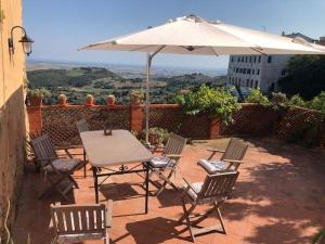a table and chairs with an umbrella on a patio at Frantoio-di-Campiglia in Campiglia Marittima