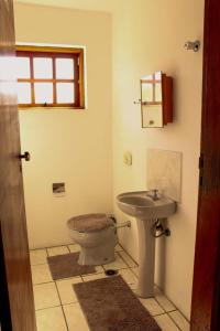 a bathroom with a toilet and a sink at Excelente Apto a 2 km CENTRINHO TURÍSTICO in Campos do Jordão