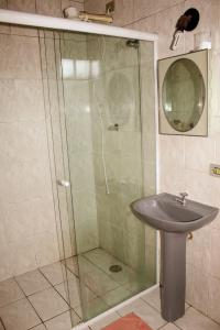 a bathroom with a shower and a sink at Excelente Apto a 2 km CENTRINHO TURÍSTICO in Campos do Jordão +12 photos