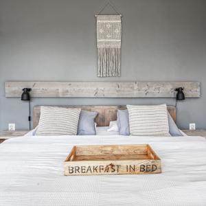 a bed with a breakfast in bed sign on it at Appartementen Sonnenhof in De Koog
