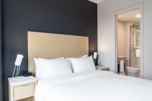 Postel nebo postele na pokoji v ubytování Griffintown Hôtel