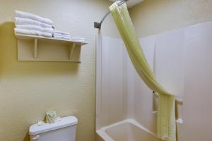 a bathroom with a shower and a toilet and towels at Continental Inn - Charlotte in Charlotte