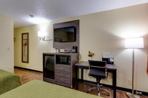 um quarto de hotel com uma secretária e uma cadeira em Continental Inn - Charlotte em Charlotte