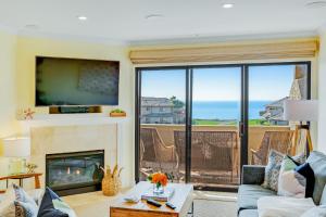 a living room with a fireplace and a view of the ocean at Seascape Sanctuary in Aptos