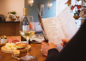 a person sitting at a table with a glass of wine at Hotel Steeds aan Zee in Katwijk